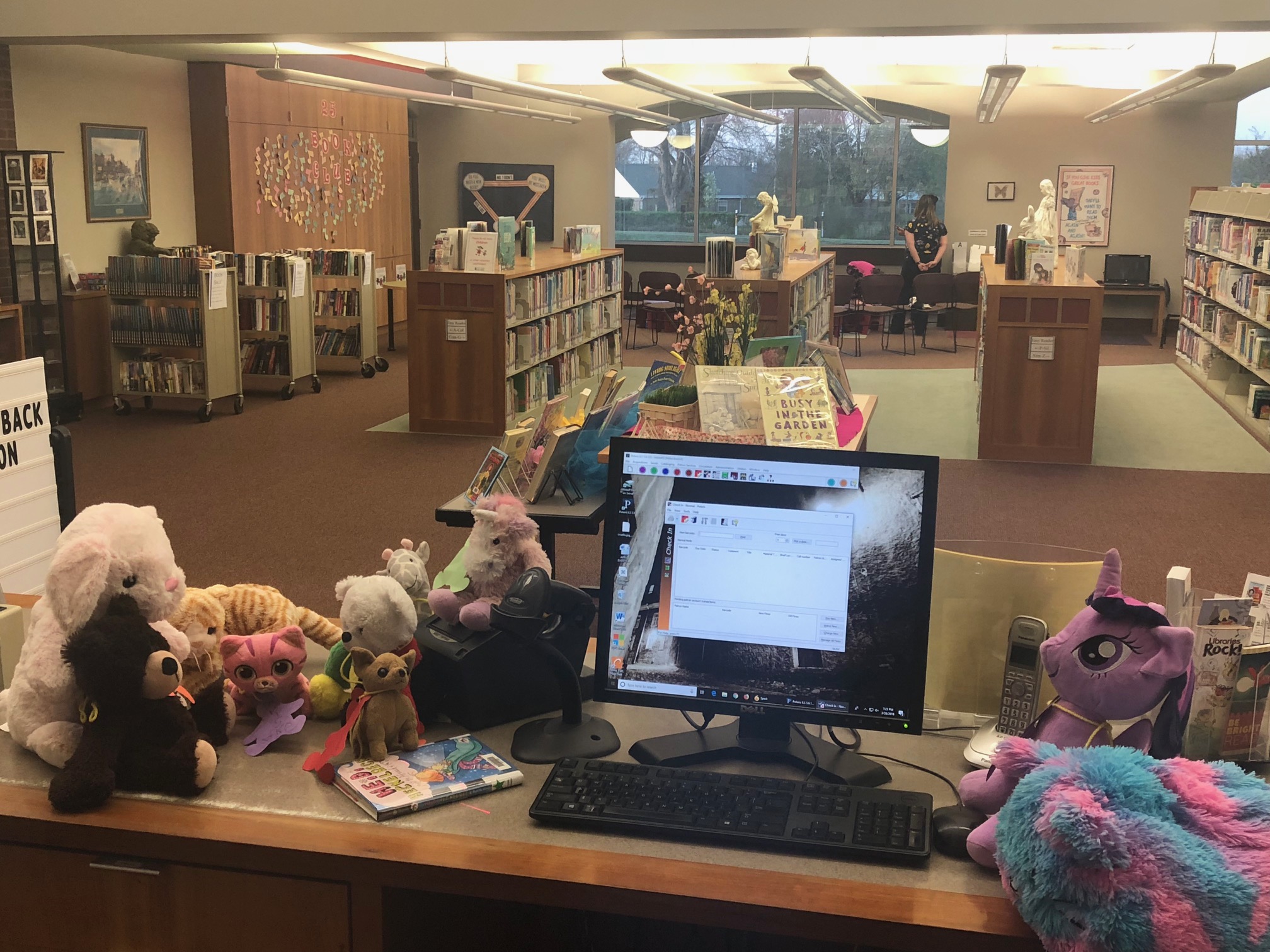 Stuffed animals helping check in books.
