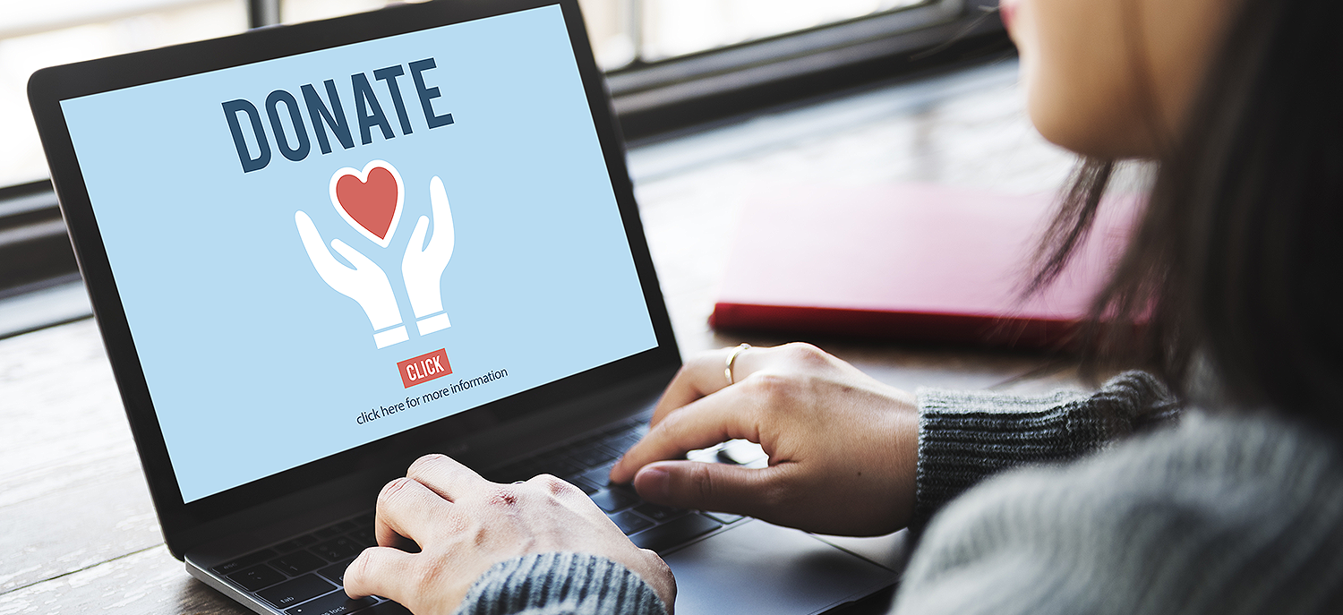 Woman typing on laptop that says "Donate" on screen