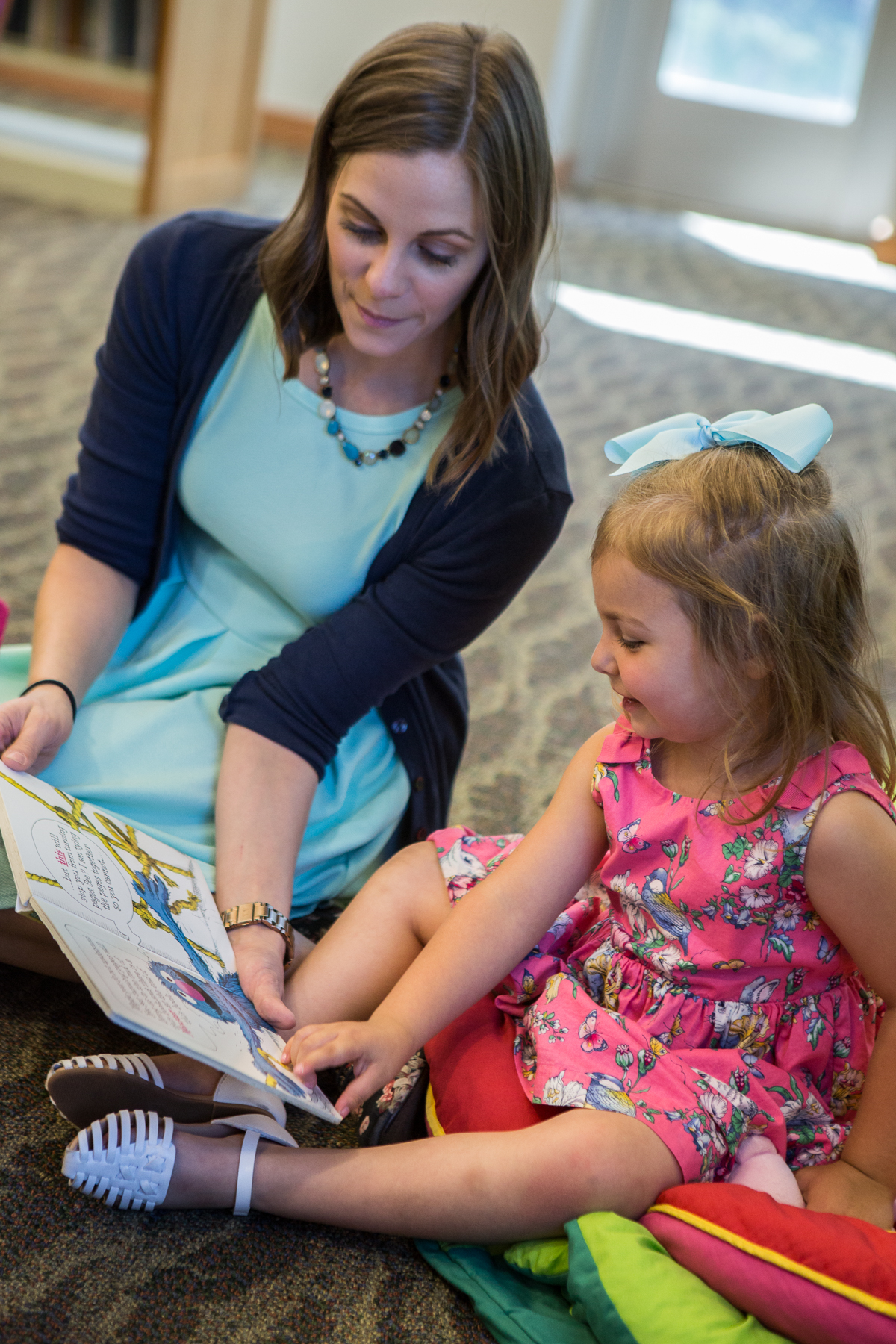 Librarian and little girl looking at book