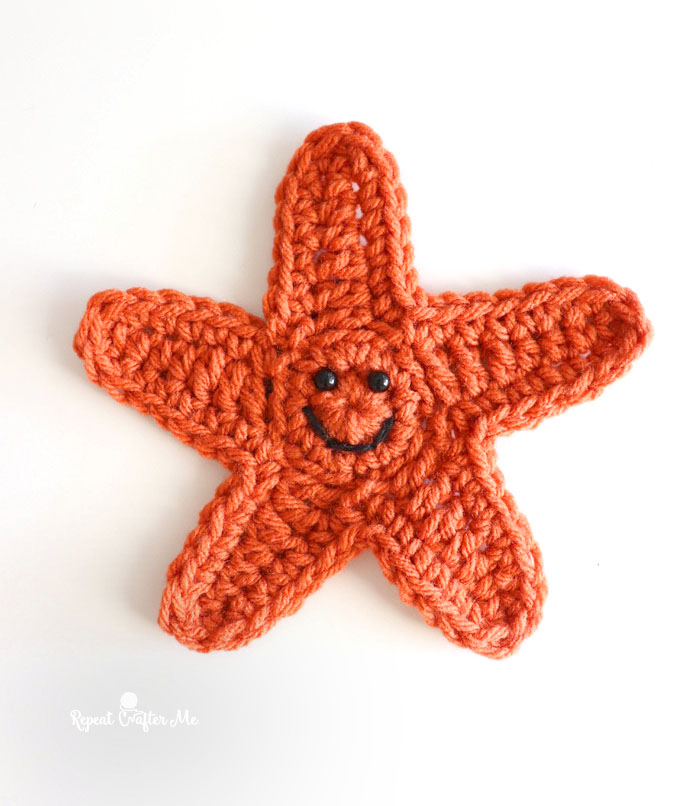 Orange starfish with a smile against a white background