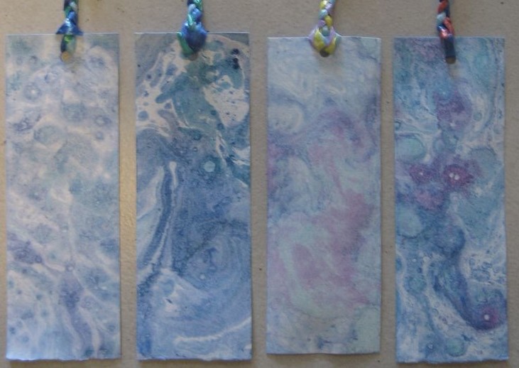 Four marbled bookmarks in various colors and marbled patterns. 