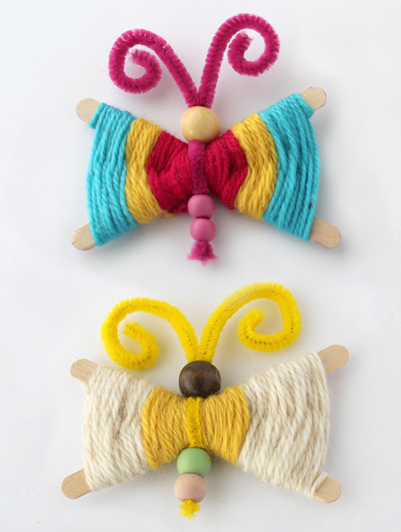 Two yarn butterflies made with multicolored yarn and beads. 