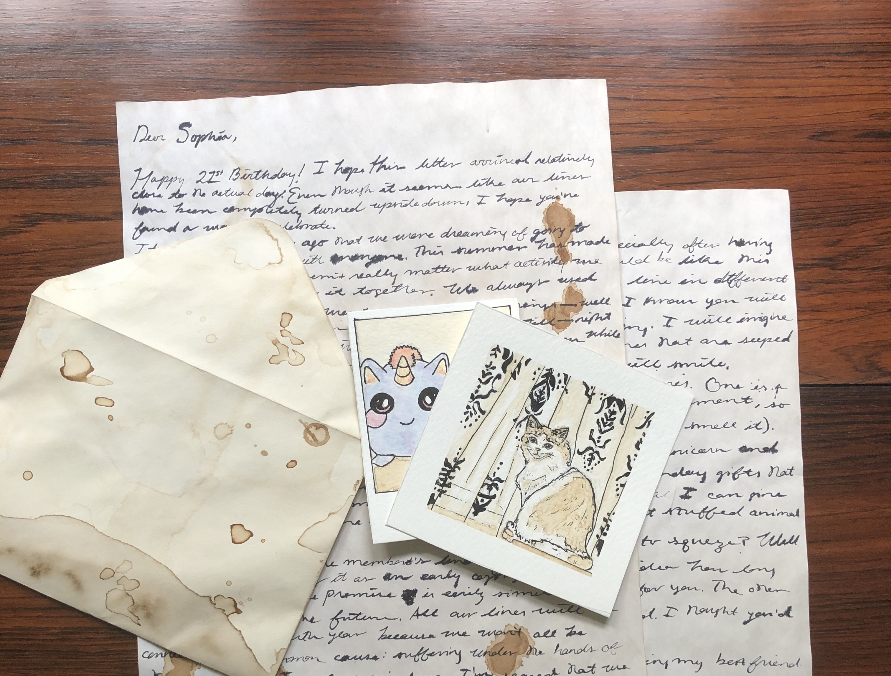 Handwritten letters, envelope, and images on wood table