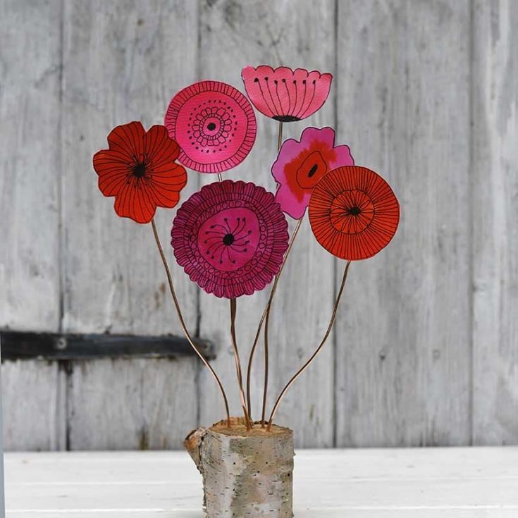 Doodle flowers in pink color against a wood background. 