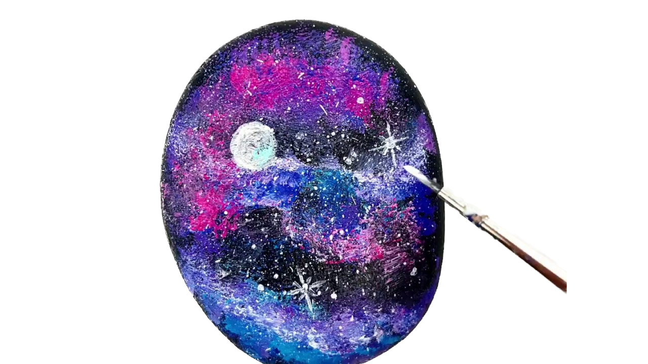 Galaxy rock with multicolors on it with a paintbrush painting something. 