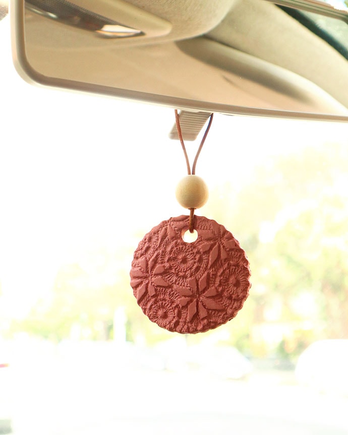 Scent Diffuser hanging from a car rearview mirror. 