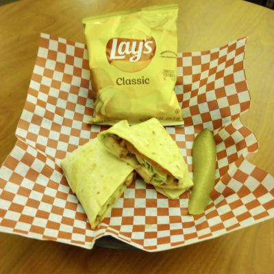 Chicken Wrap with potato chips and a pickle