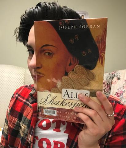 example of someone making a bookface by holding up a book to their face