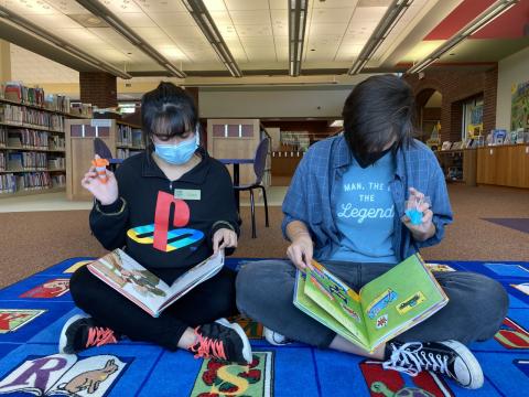 two people reading to their reading buddies