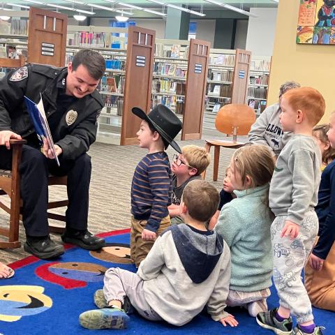 police officer reading a children's book at storytime
