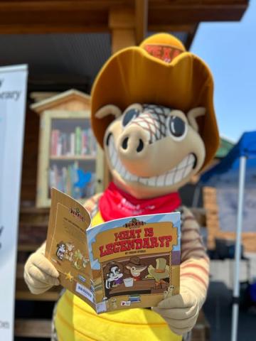 Andy the Armadillo mascot from Texas Roadhouse reading a book
