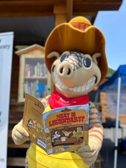 Andy the Armadillo mascot from Texas Roadhouse reading a book