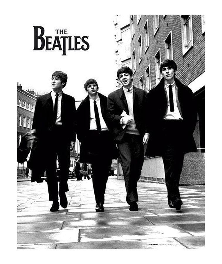 Black and white photo of The Beatles music group walking down the street