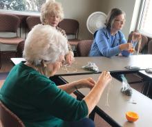 Adults making a library macrame craft 